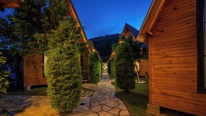 A wooden cabin-style building with a stone pathway leading to a wooden door. - Karaöz Sapphire Bungalows (Kumluca)