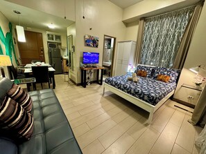 A modern bedroom with a bed, a desk, and a sofa. - Beautiful Corner Studio Near Resorts World Manila Across NAIA Terminal 3 (Pasay)