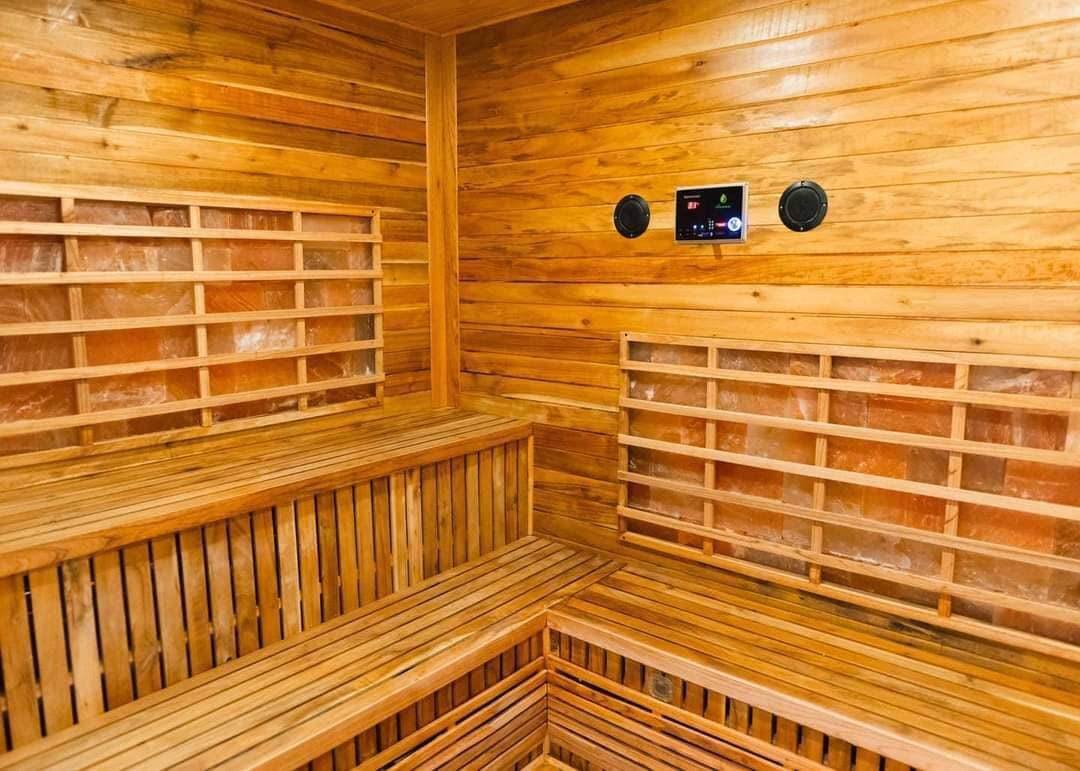 Un sauna avec des bancs en bois et un panneau de commande.