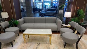 A modern lobby with a marble floor, a sofa, and two armchairs. - Sky View Hotel Madinah (Madinah)