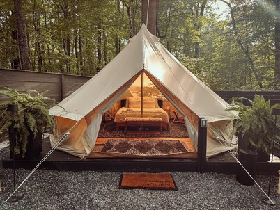 A luxurious glamping tent nestled in the trees.