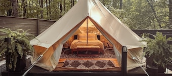 A luxurious glamping tent nestled in the trees.