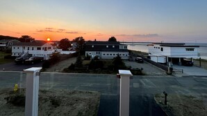 Eine Küstenwohngegend mit Häusern, einem Jachthafen und einem Sonnenuntergang.