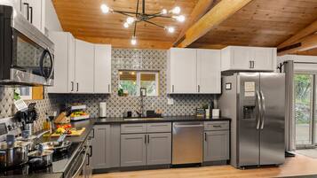 The kitchen from the other side. Near the patio doors and flowing effortlessly to the dining table, natural light, and enough room to actually enjoy cooking together.