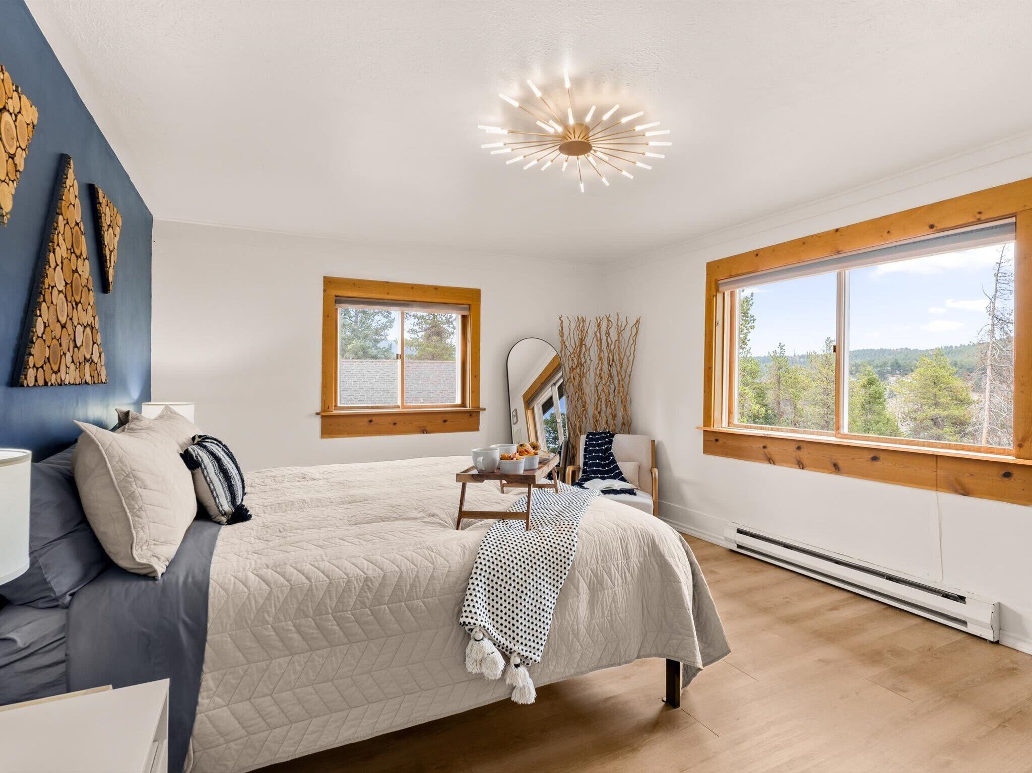 Two windows full of Colorado forest, a king bed with room to stretch out, and a chandelier that catches the light just right. Sleep comes easy here.