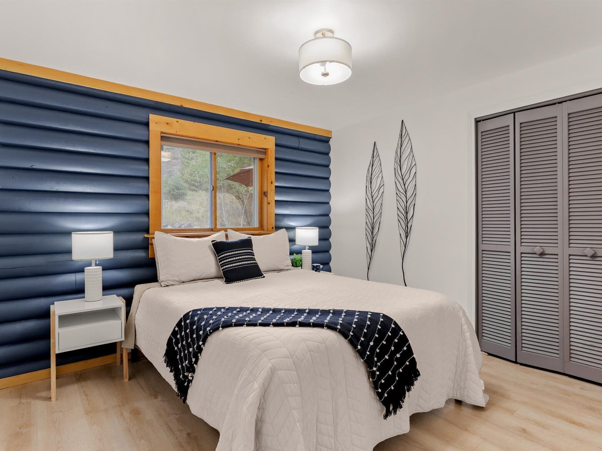 The queen third bedroom. Same blue logs, same tree views, a little cozier. Someone in your group is going to love it.