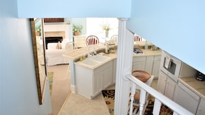 A compact kitchen with white cabinets, a sink, and a stove.
