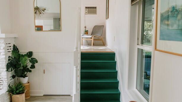 A staircase with green carpet, a white door, and a mirror on the wall. - Beautiful cottage w/pool in bamboo forest! (Central Point)
