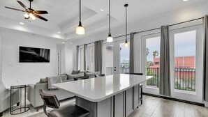 A modern kitchen with a central island, pendant lighting, and large windows with curtains. - 5909 Havana Dr: Private Pool/Large Back Yard (South Padre Island)