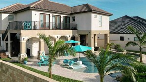 A two-story house with a balcony, a swimming pool, and outdoor seating. - 5909 Havana Dr: Private Pool/Large Back Yard (South Padre Island)