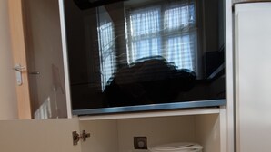 Et køkken med indbygget ovn, en glas skål og en hvid beholder på bordet.