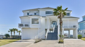 Ein zweistöckiges Haus mit Veranda, Garage und einer Treppe, die zum Eingang führt.