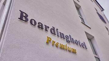 Un immeuble sur lequel on peut lire l’inscription : « Boardinghouse Premium ».