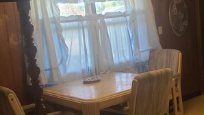 A dining area with a wooden table and four chairs.