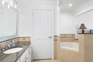 A bathroom with two sinks, a bathtub, and a door. - Amazing Golf View Condo Best view in Reunion! (Kissimmee)