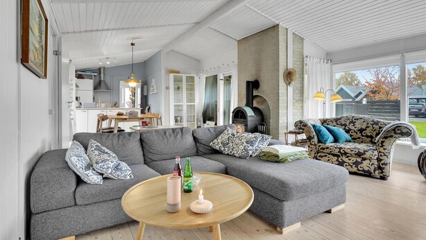 A modern living room with a sectional sofa, a round coffee table, and a fireplace. - Cozy home in Karrebæksminde with WiFi (Karrebæksminde)