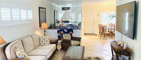 A living room with a sofa, chairs, a coffee table, and a dining area with a table and chairs.