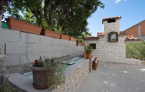 A stone wall with terracotta planters and a small brick structure labeled 'Ships Inn'.