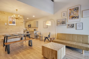 A modern interior with a dining area, a sofa, and artwork on the walls.