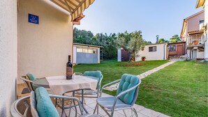 An outdoor patio with a table and chairs, a wine bottle, and a sign indicating a restaurant. - 2 bedroom awesome home in Banjole (Banjole)