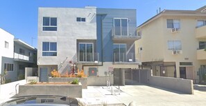 Stylish residential building with balconies and windows, offering an entrance and landscaped garden.