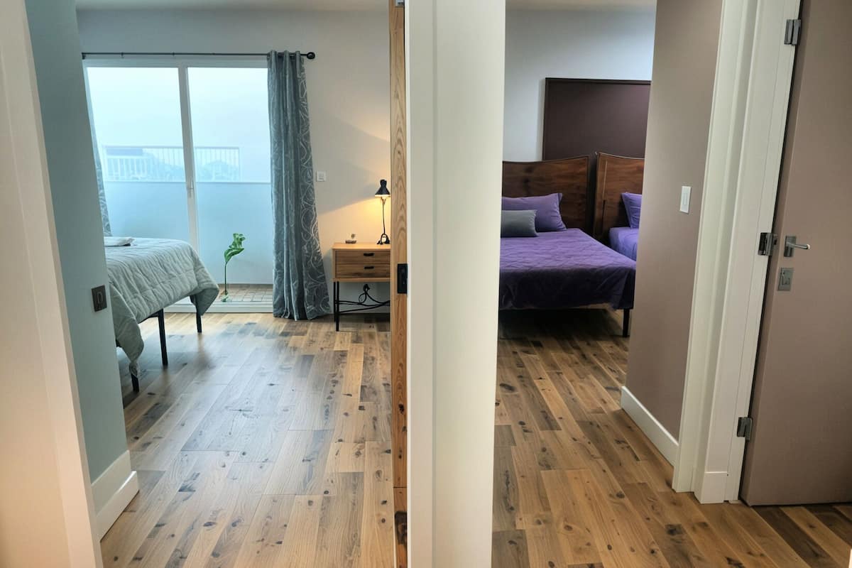 Une chambre à coucher avec un lit, un bureau et une fenêtre avec des rideaux.
