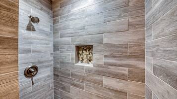 Ducha con pared de azulejos de madera y una ventana pequeña.