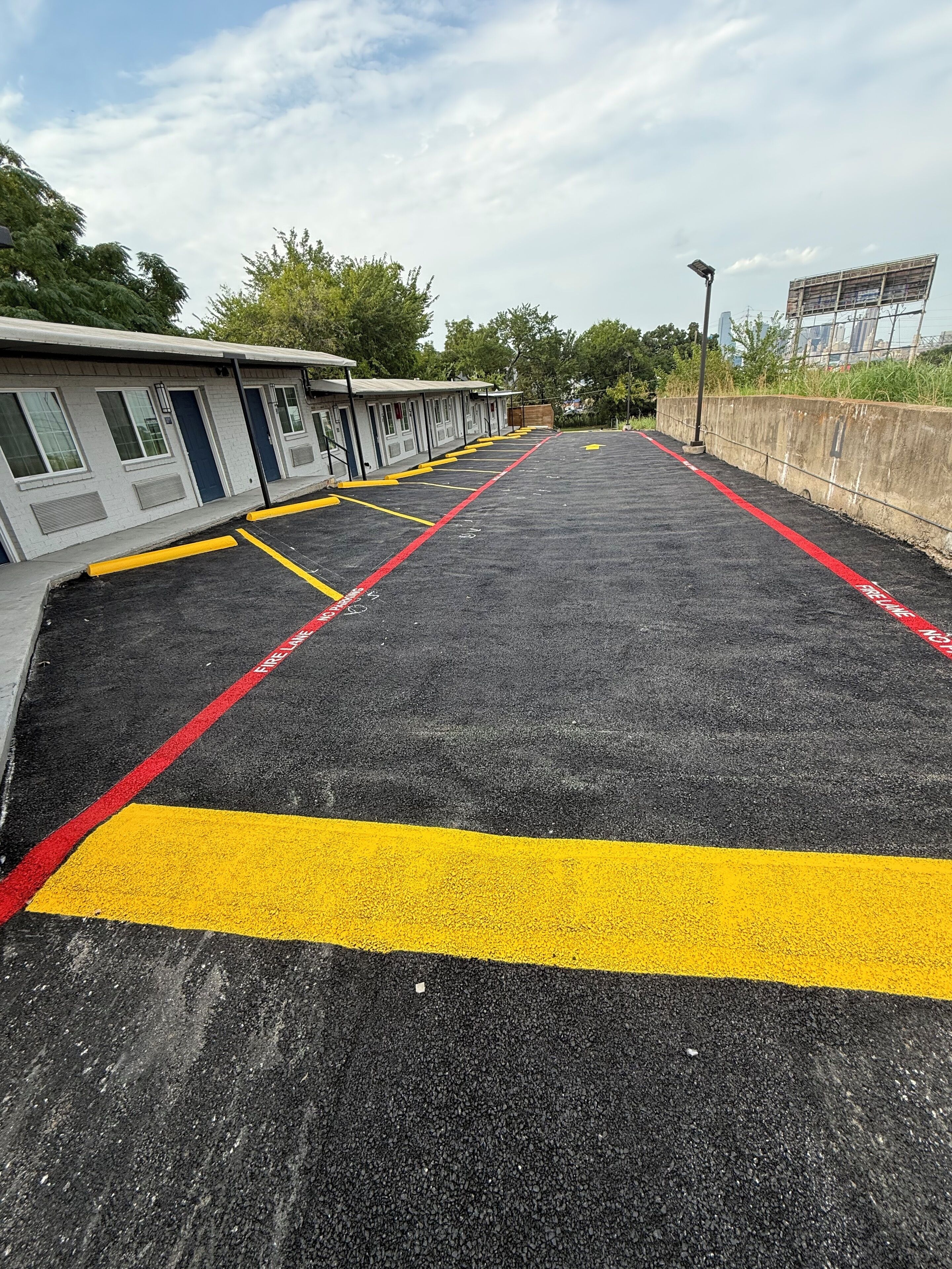Ein Parkplatz mit ausgewiesenen Feuerwehrzufahrten und einer Reihe von Motelgebäuden.