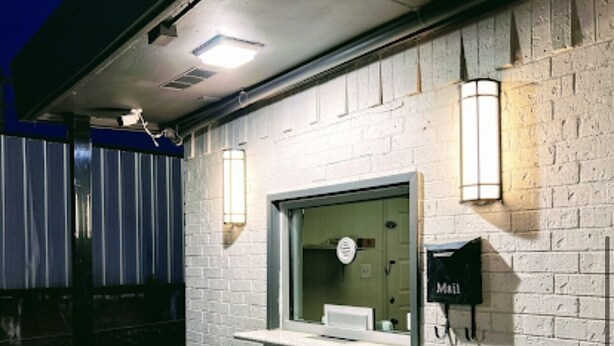A brick wall with a mailbox and two wall-mounted lights. - Bishop Arts Suites (Dallas)