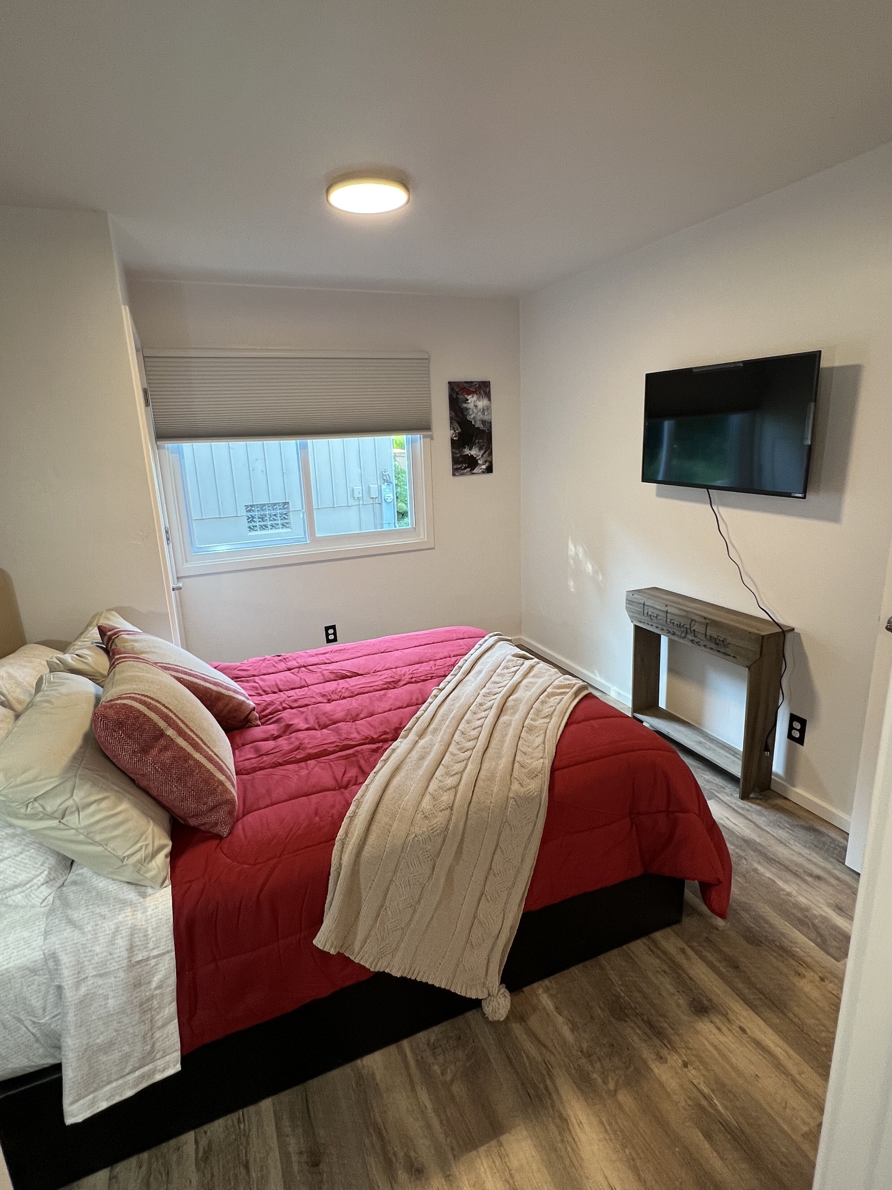 Una camera da letto con un letto, una finestra, una TV e un caminetto.