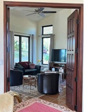 A spacious living area with a sofa, coffee table, and a television.