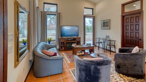 A spacious living room with a large TV, comfortable seating, and a dining area. - Ocean Breezes VRBO (Fallbrook)
