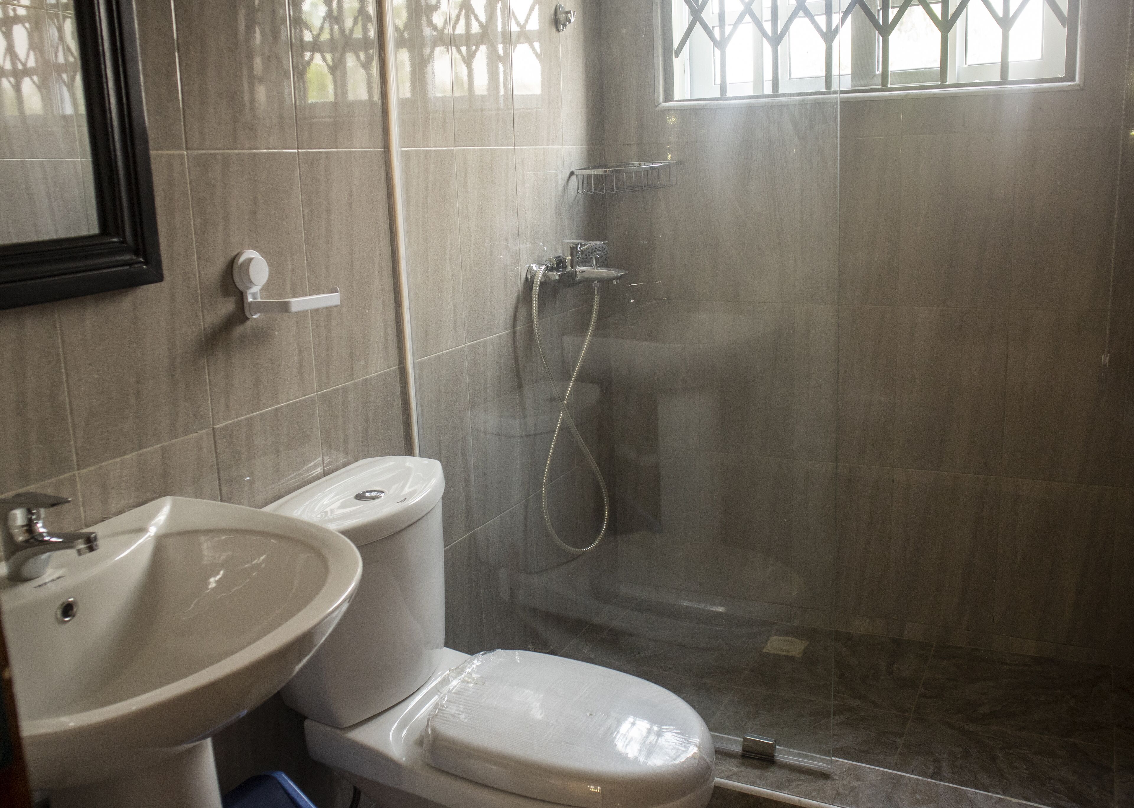 A bathroom with a toilet, sink, and shower.