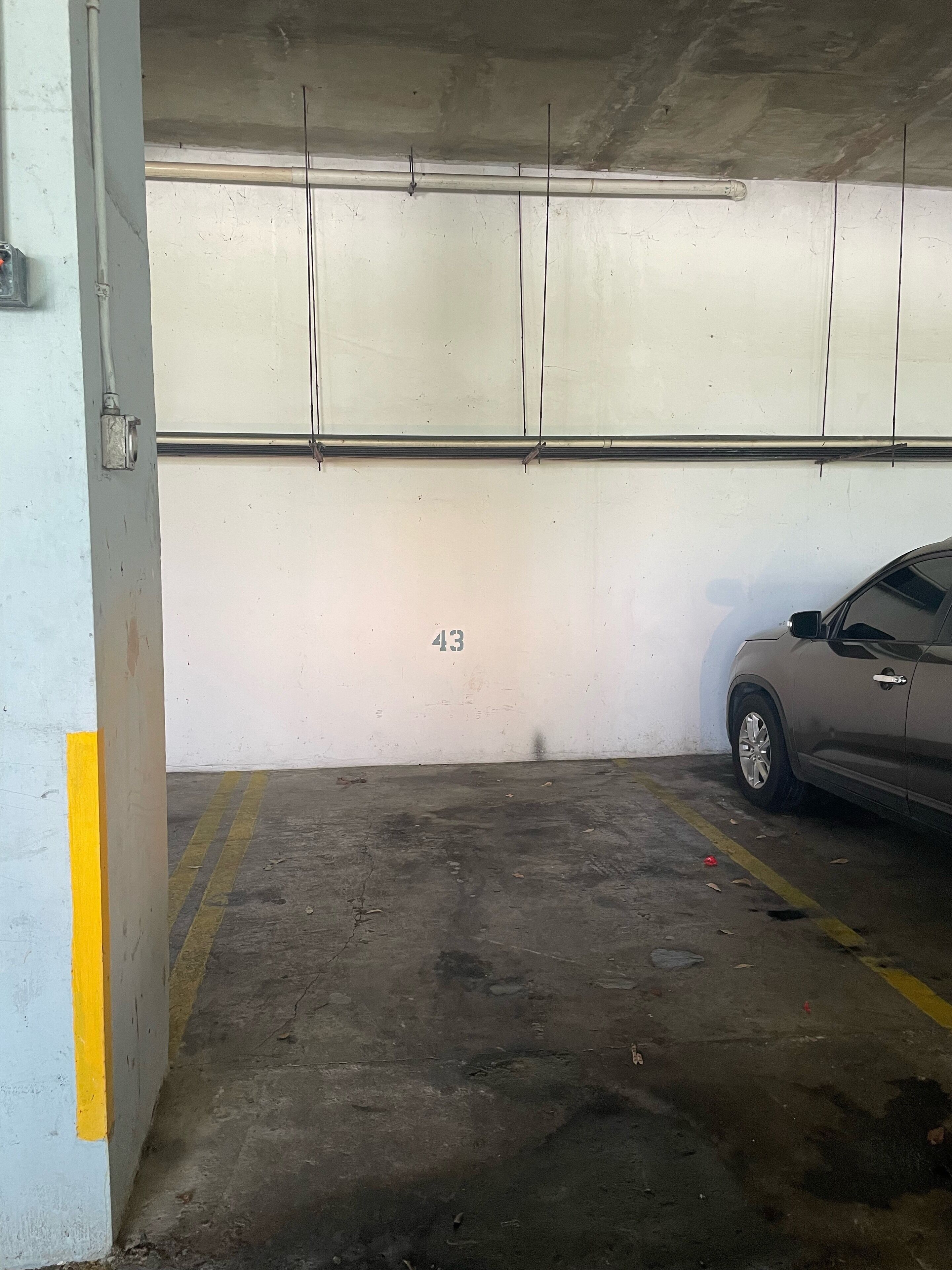 A parking garage with a car parked in a spot marked '43'.