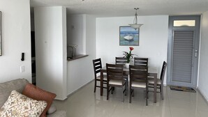 Un espace repas comprenant une table et des chaises, un ventilateur de plafond, un tableau et une porte.