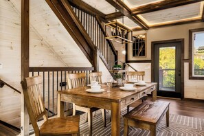 Enjoy meals in this inviting dining area with a wooden table, comfortable chairs, and a bench.