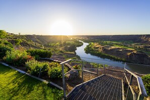 A river valley with a metal bridge and a grassy area with plants. - Canyon Rim Home - Heated Pool, Hot Tub, Game Room (Twin Falls)