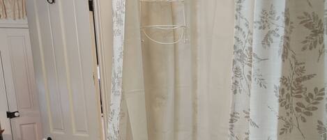 A bathroom with a shower curtain, a towel rack, and a toilet.