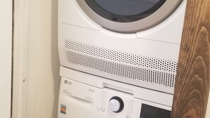 Una lavadora y secadora apiladas, con panel de control, motor de transmisión directa y pantalla digital.