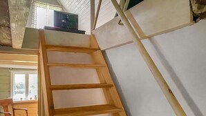 A wooden ladder against a white wall with a window and a chair visible in the background. - 3 bedroom cozy home in Lärbro (Lärbro)