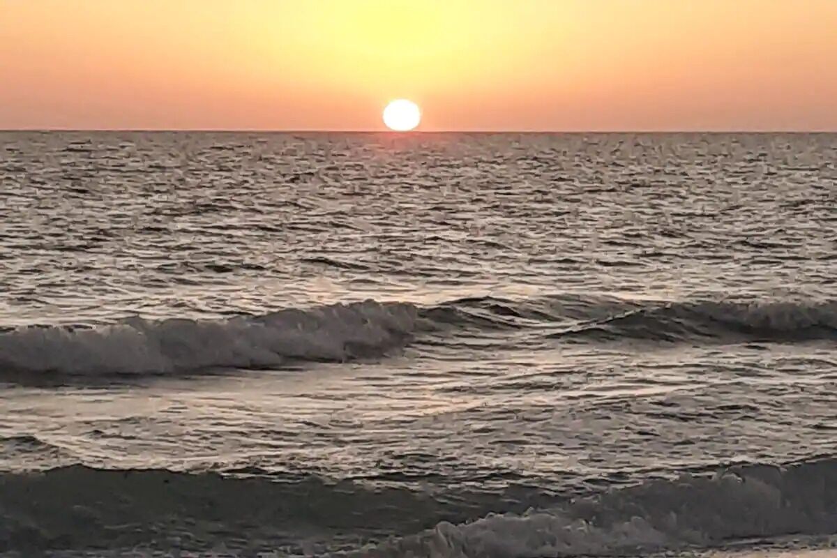 Un atardecer sobre el océano con olas.