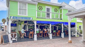 A green building with a sign reading "Rum Runner's Bar & Grill". - Beautiful Condo on the Beach in Freeport! (Freeport)