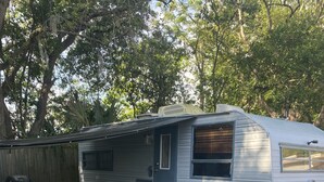 A mobile home with a porch, a grill, and a fire pit. - Retro Rv adorable little romantic paradise (Casselberry)