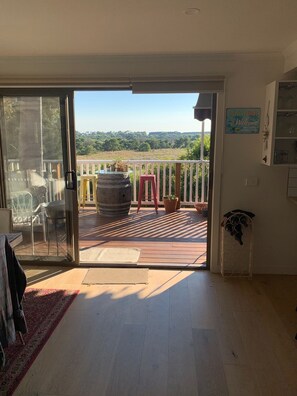 Enjoy the serene view of lush green surroundings from this open-plan living space with access to a deck.