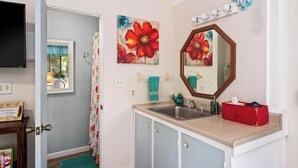 A bathroom with a sink, mirror, and decorative flowers. - Peaceful Mountain Retreat- Jungle Mountain Vibes (Holualoa)