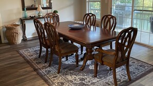 A dining room with a wooden table, six chairs, a large mirror, and a chandelier. - Lake Hamilton, BoatHouse, Hot Tub, 
Barge Rental, Sleeps 10, H.S. National Park (Hot Springs)