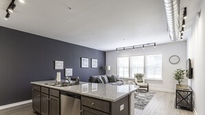 A modern kitchen with dark cabinetry, a granite countertop, and a built-in dishwasher. - Beautiful 1BR in Midtown and the Medical District  (Memphis)