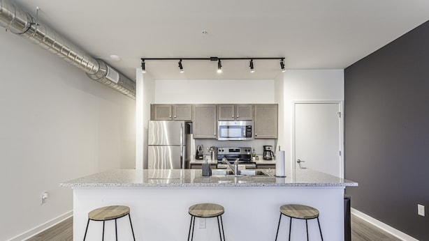 A modern kitchen with a central island, stainless steel appliances, and bar stools. - Beautiful 1BR in Midtown and the Medical District  (Memphis)