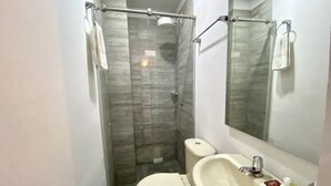 A small bathroom with a toilet, sink, and glass shower enclosure. - suite old city 11br jacuzzi Ac Hot water (Cartagena de Indias)