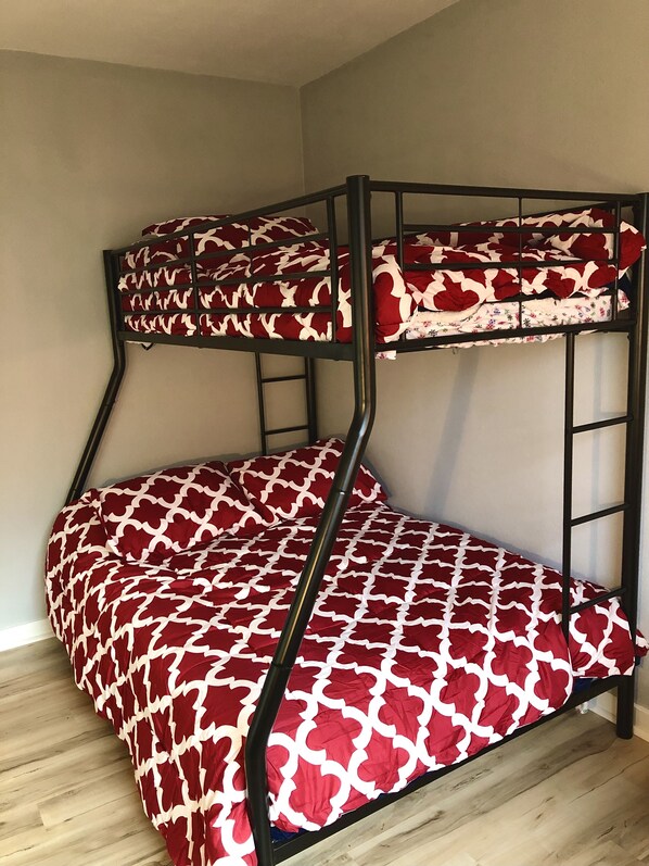 A bunk bed with a red and white patterned bedspread. - NEW Central Air!! Cute, family home, large fenced backyard and patio area! (Dubuque)